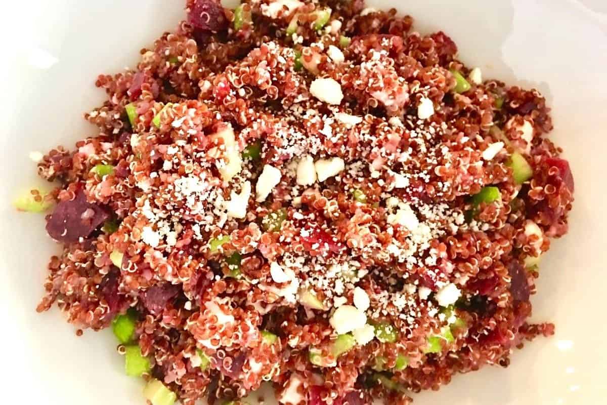 overhead photo of quinoa beet salad in a white bowl with feta and celery.