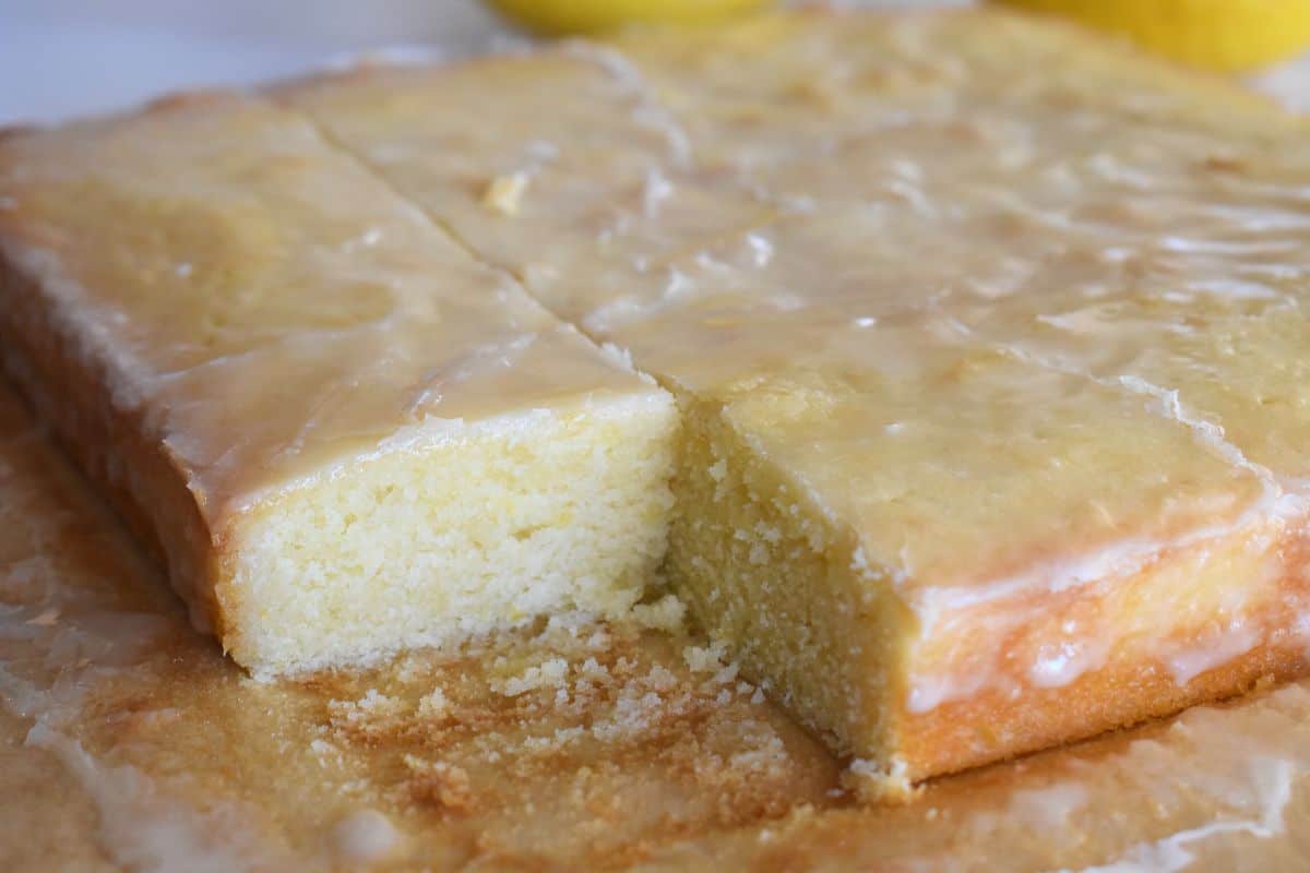 Lemon Blondies on parchment paper with a square of blondie taken out. 