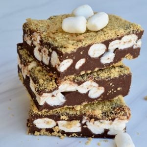 S'mores Fudge stacked on each other with marshmallows on top.