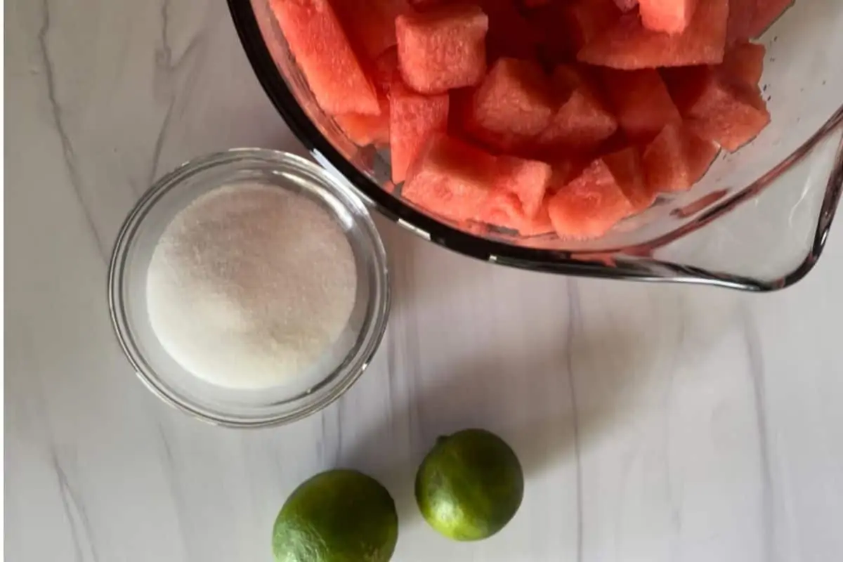 overhead photo of ingredients including the melon, sugar, and limes. 