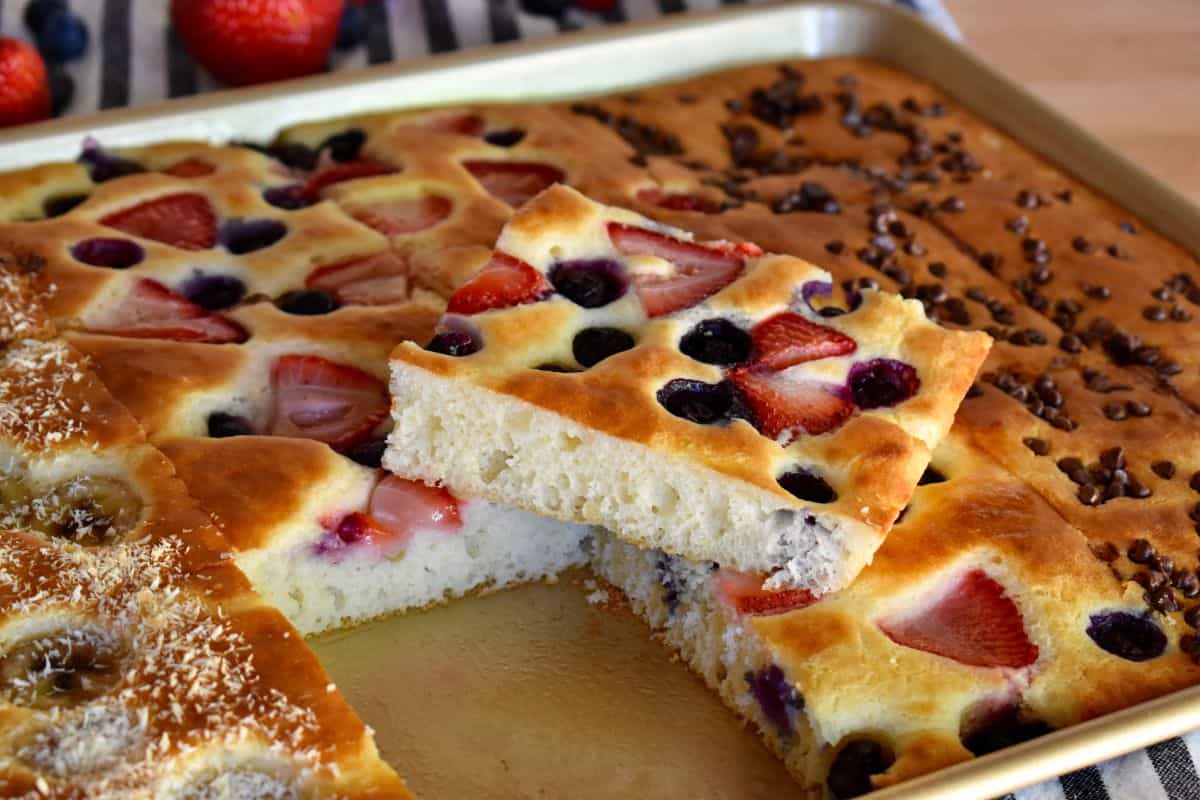 Sheet Pan Pancakes from Mix with berries on top in a sheet pan on the counter.