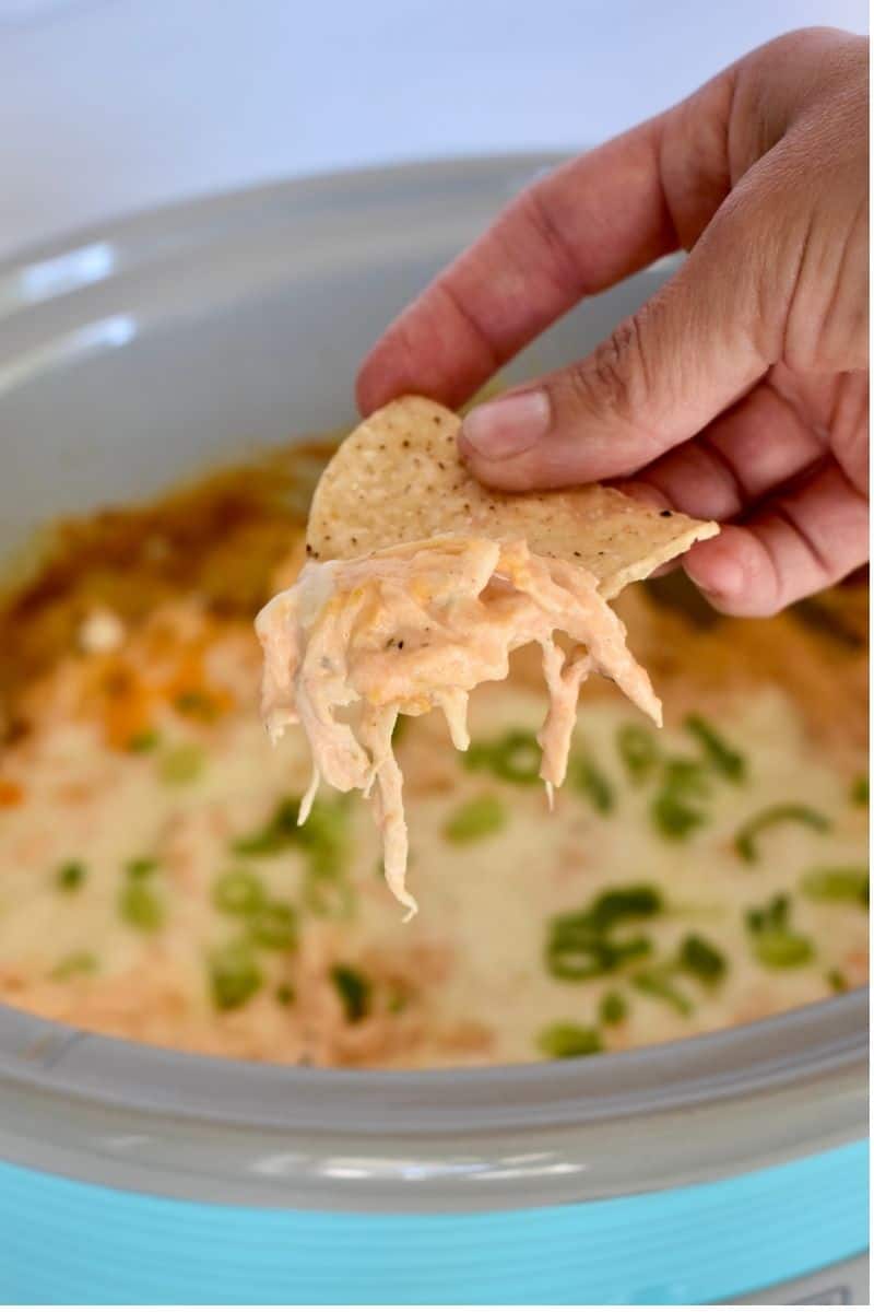Slow Cooker buffalo chicken dip with a tortilla chip. 