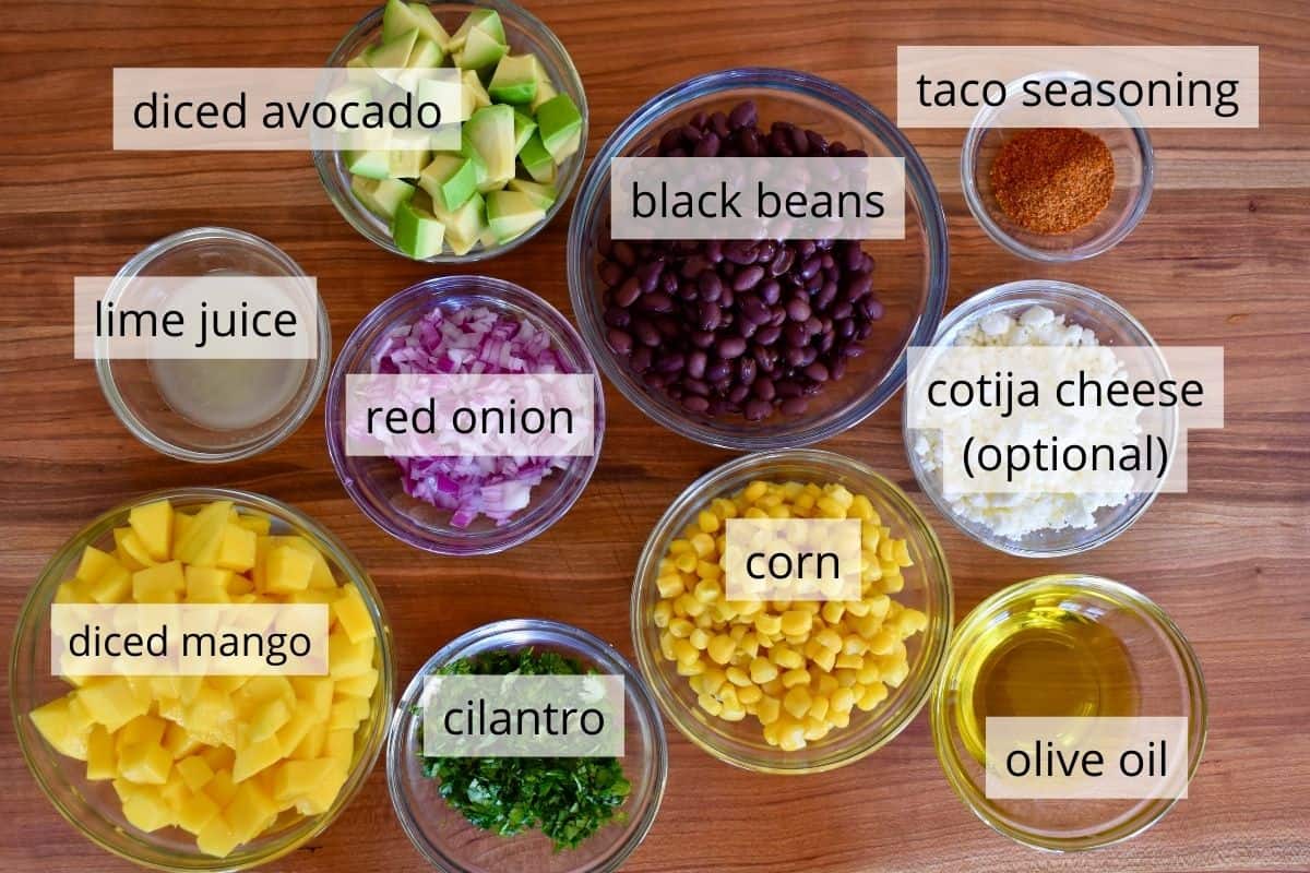 overhead photo of ingredients including red onion, corn, avocado, lime juice, and cilantro. 