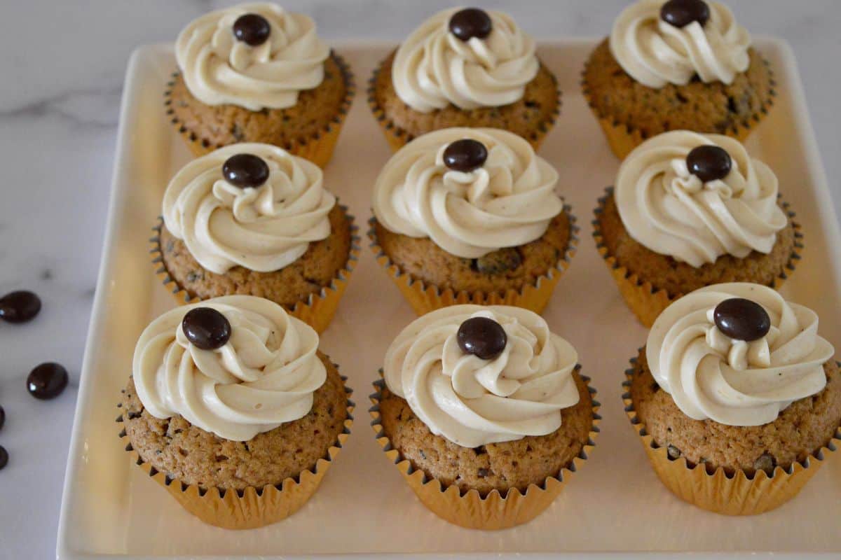 Espresso Cupcakes on a white serving tray with chocolate covered espresso beans on top. 