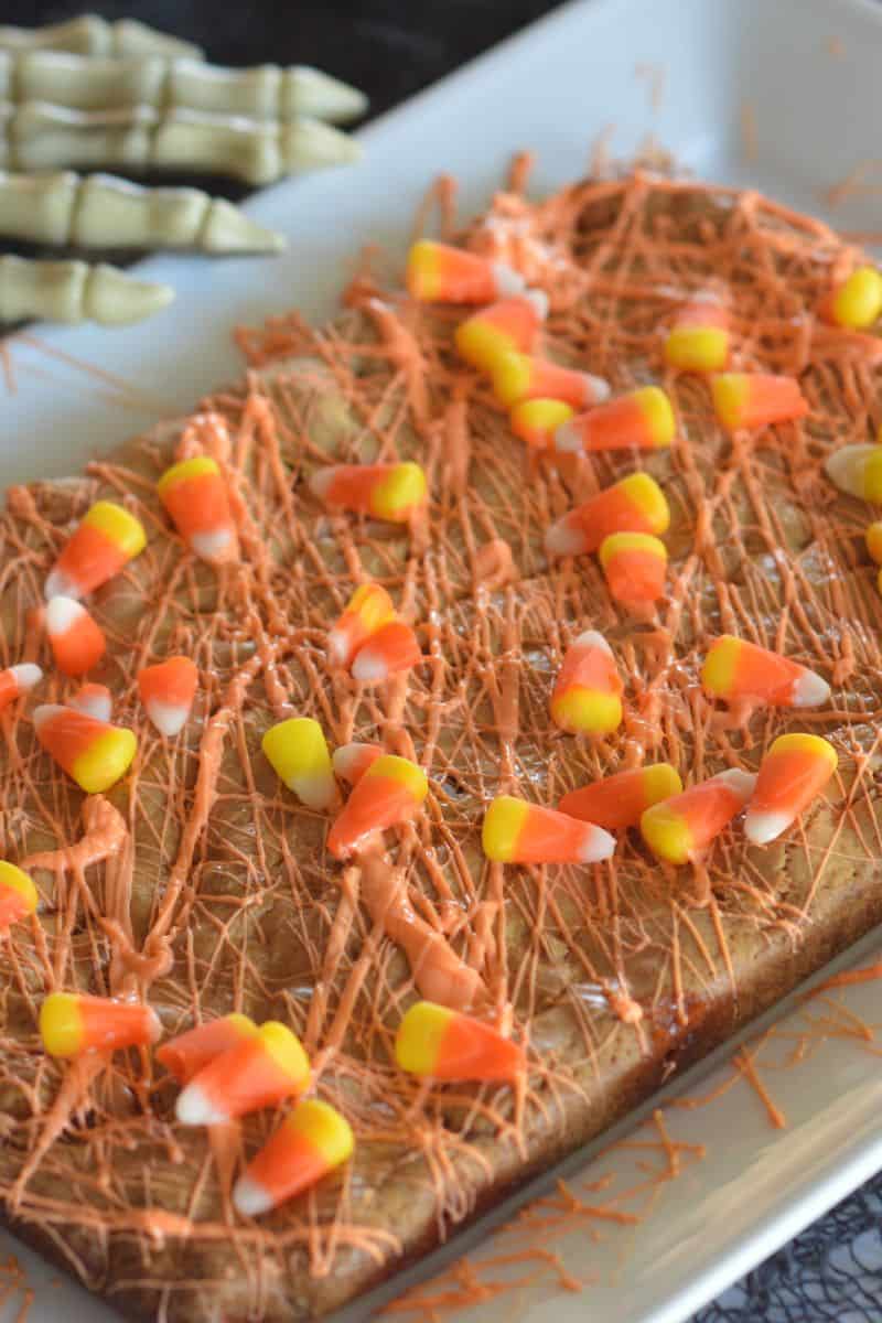 Halloween bars on a white serving platter with orange drizzle on top. 