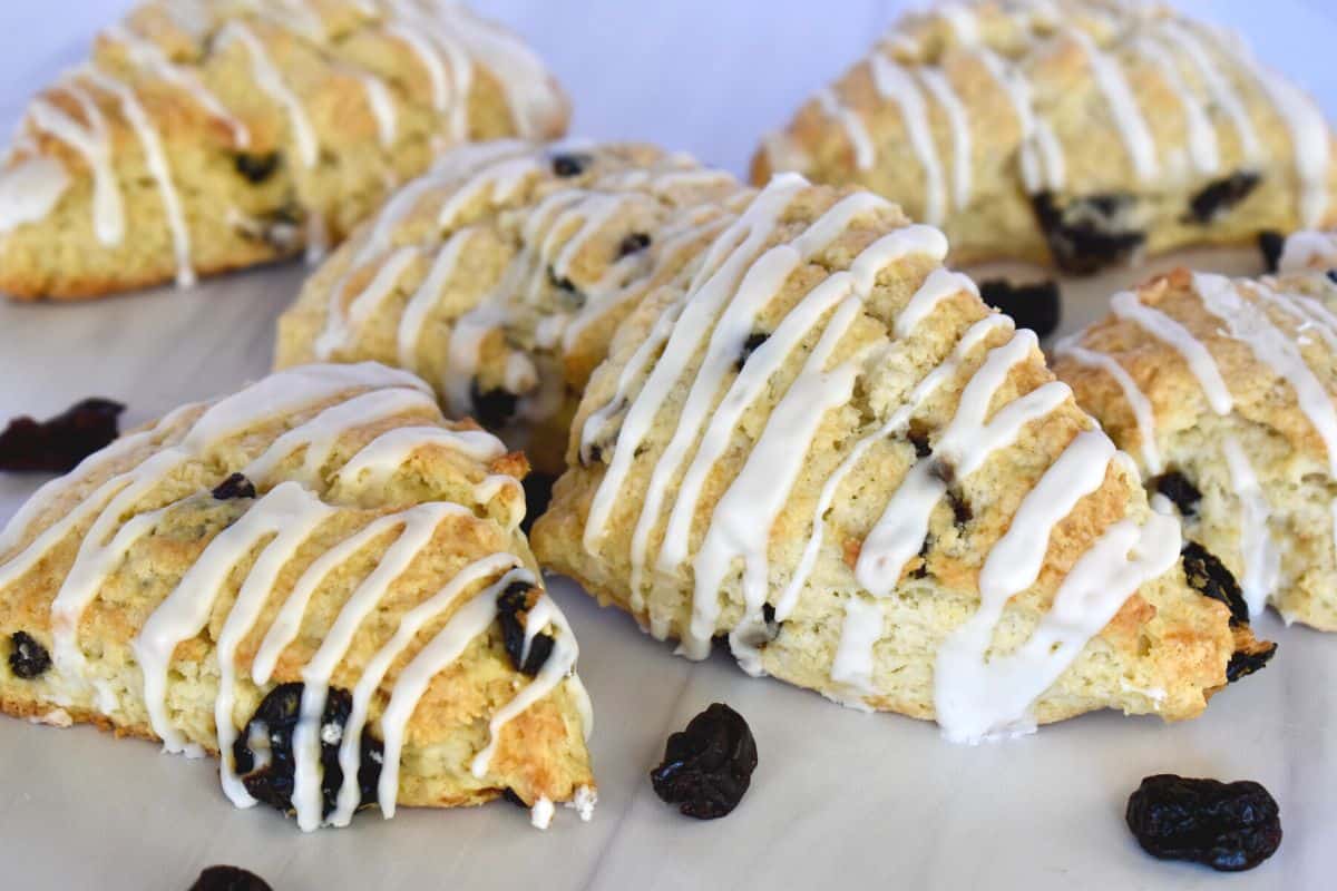 Cherry Scones with almond glaze and dried cherries on a white countertop. 