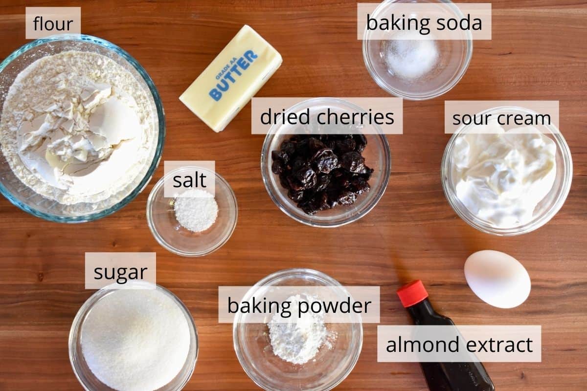 overhead photo of ingredients including flour, baking powder, butter, sour cream and almond extract. 