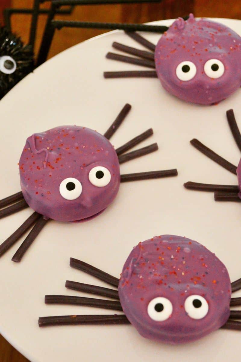 Oreo Spiders with a purple coating on a white plate.