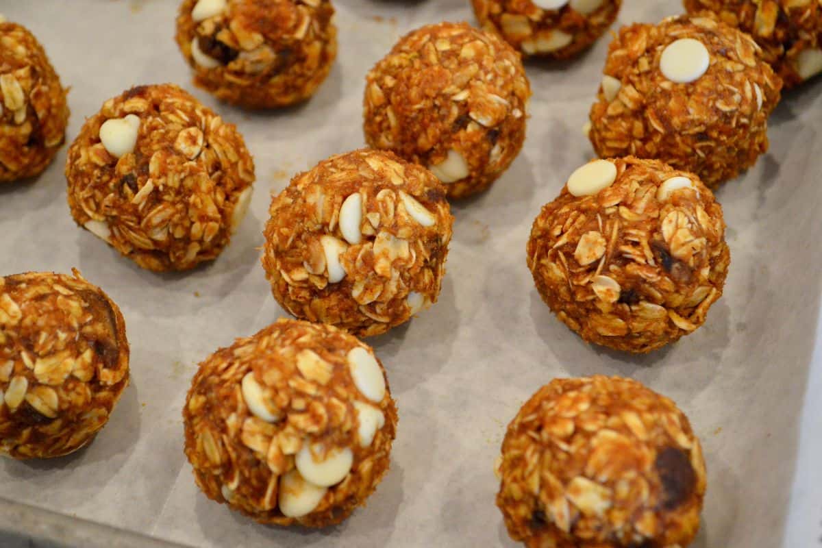 Pumpkin Protein Balls rolled into balls on a baking sheet lined with parchment. 