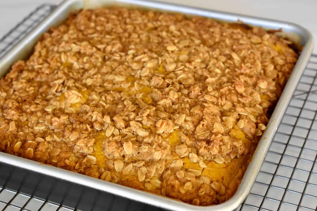 Pumpkin Streusel Coffee Cake in a baking pan on top of a cooling rack. 