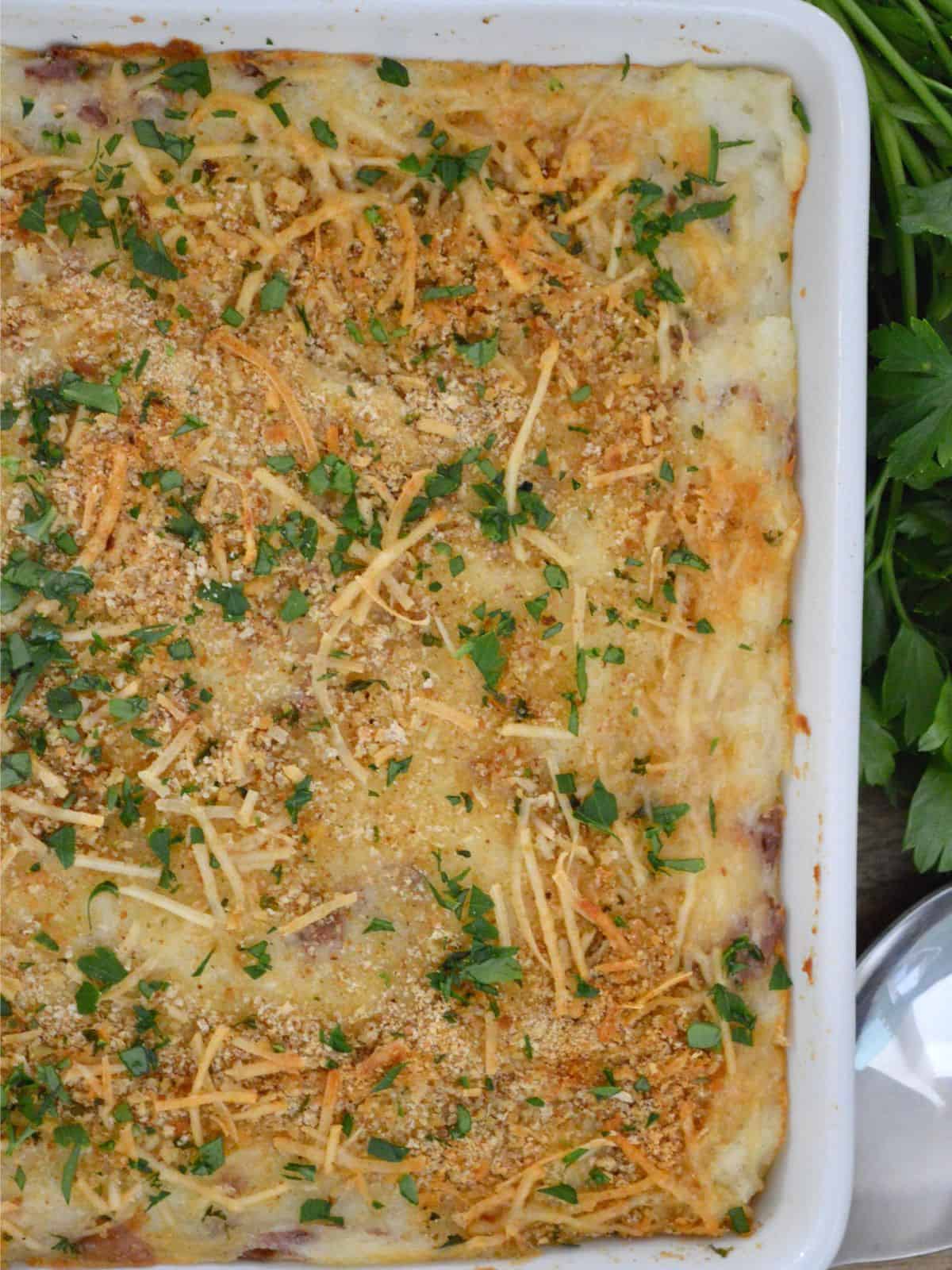 Italian mashed potatoes with a breadcrumb topping in a white serving dish. 