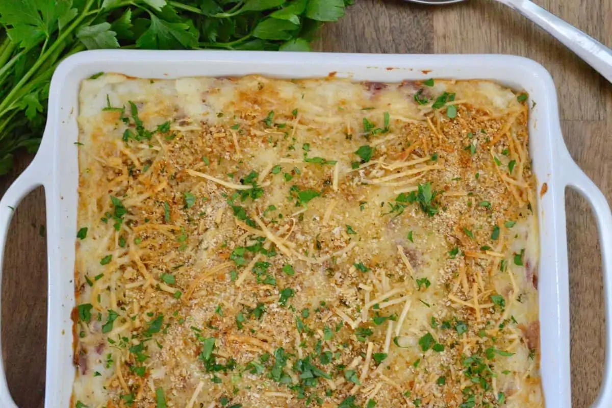 Italian Mashed Potatoes in a white casserole dish with parsley on top. 