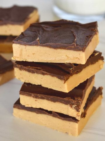 stack of no bake chocolate peanut butter bars on a countertop.