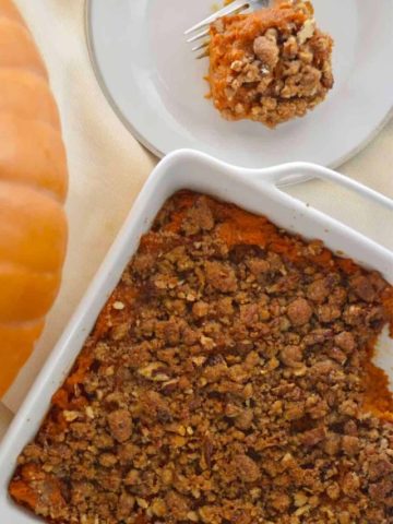 Sweet Potato Casserole with Pecan Streusel in a white serving dish.