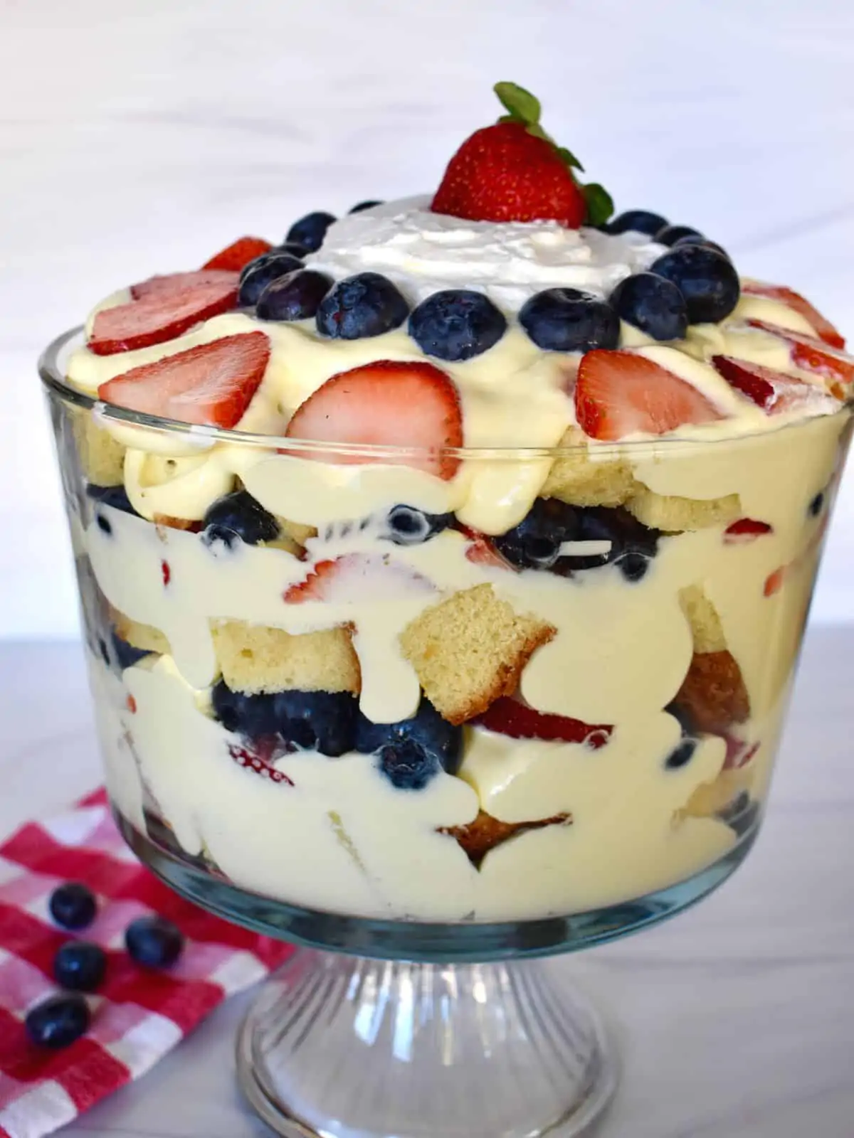 Pound Cake trifle layered in a glass trifle bowl topped with berries. 