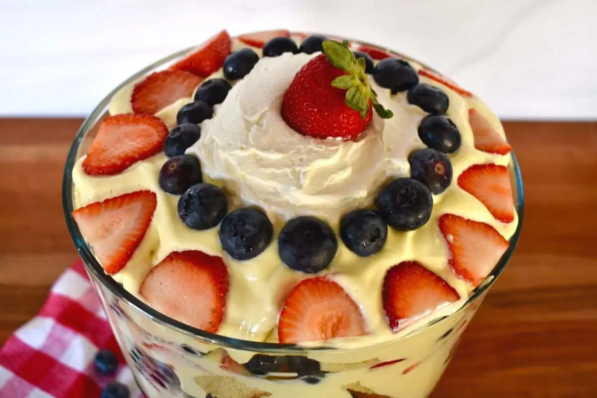 overhead photo of pound cake trifle in a glass trifle bowl with berries arranged on top. 
