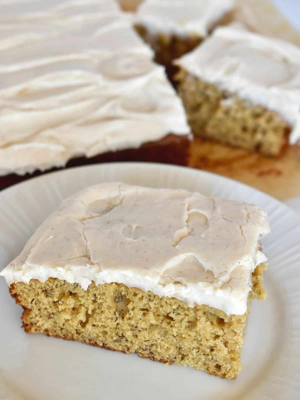 Brown Butter Banana Cake with cream cheese frosting on a white plate. 