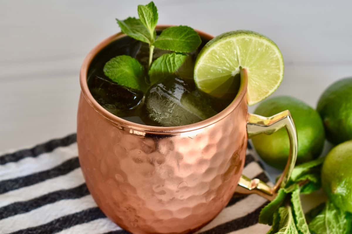 Kentucky Mule in a copper mug with a sprig of mint and lime garnish. 