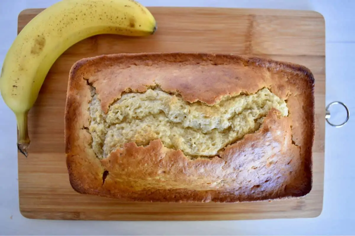 Overhead photo of a loaf of pancake mix banana bread with a banana next to it. 