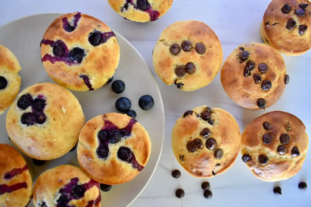 Overhead photo of blueberry and chocolate chip pancake mix muffins on a countertop. 