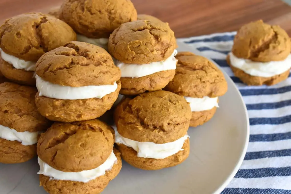 Pumpkin Whoopie Pies with Cake mix on a plate with a striped napkin underneath. 