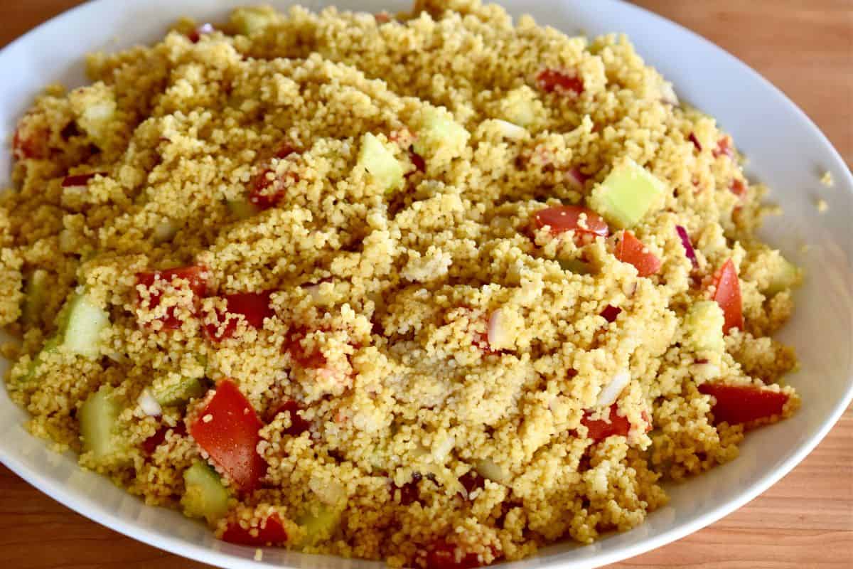 Curried Couscous recipe in a white bowl with veggies in it. 