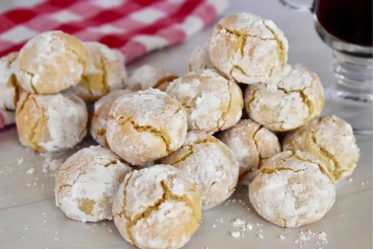 Soft Amaretti Cookies on a white countertop with a cup of coffee next to them. 