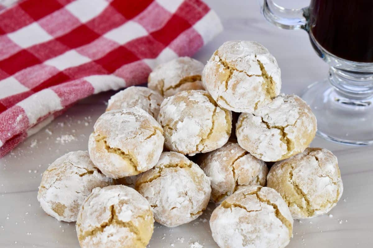 Soft Amaretti Cookies on a white surface with a checkered napkin in the background. 