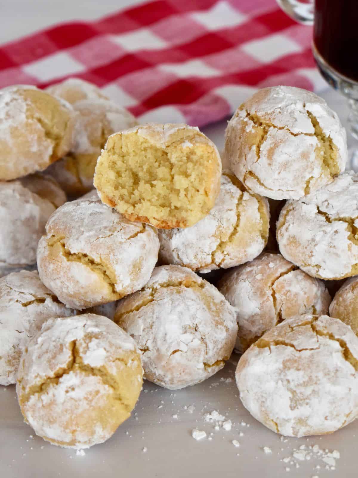 Soft Amaretti Cookies piled on each other with a checkered napkin in the background.