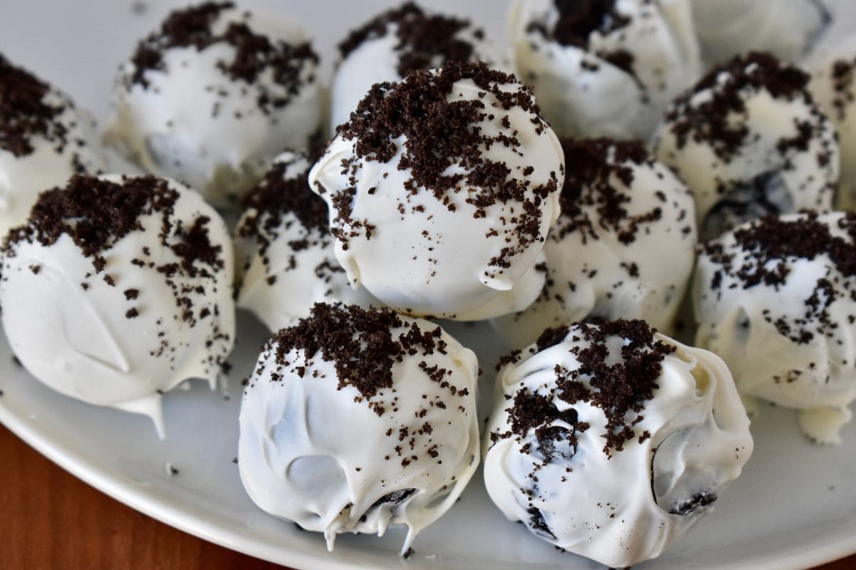 Cookies and cream truffles stacked on a white plate. 