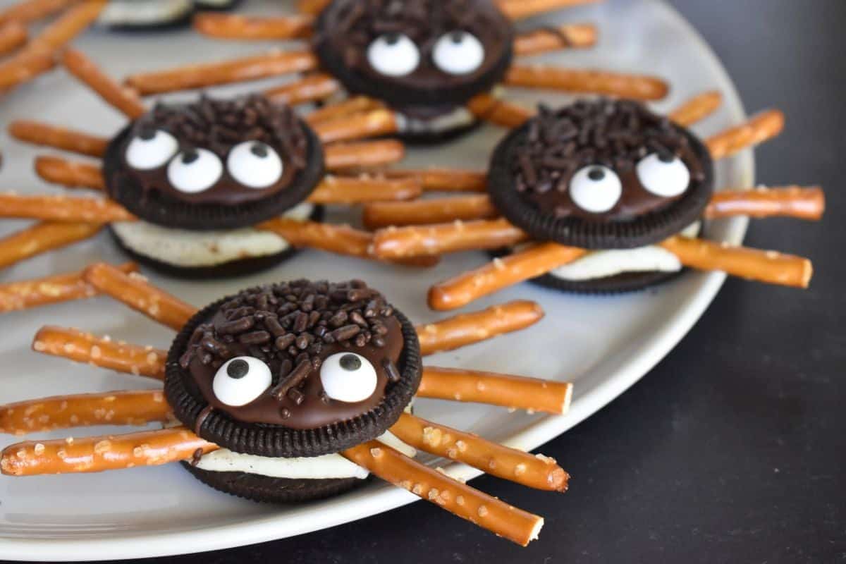 Oreo Cookie Spiders on a white plate on a black background. 