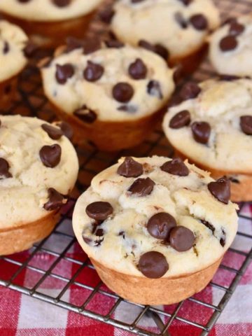 Chocolate Chip Ricotta Muffins on a wire baking rack with a checkered napkin underneath.