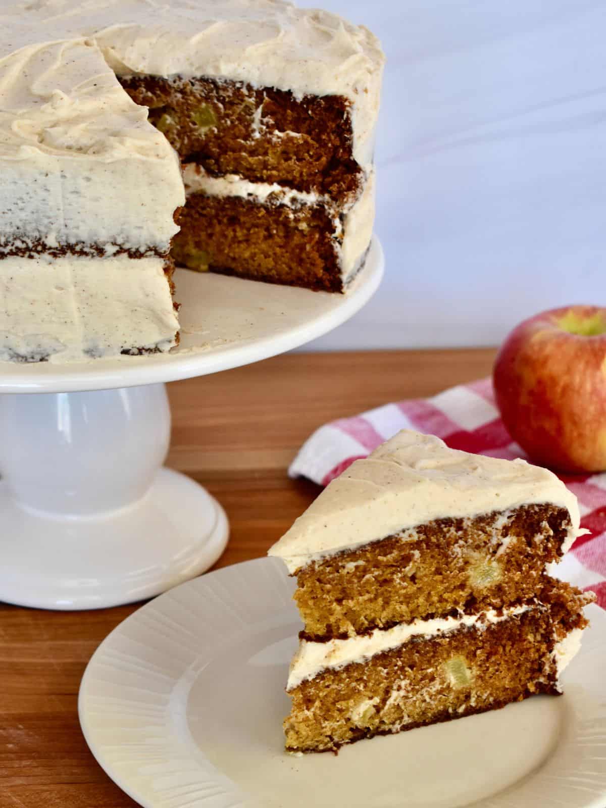 Apple Spice Cake with cinnamon buttercream frosting on a white plate. 