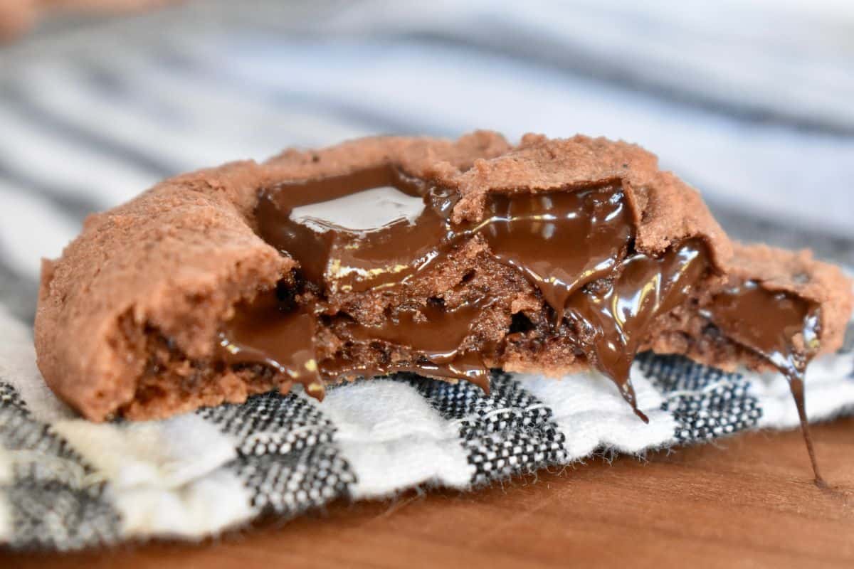 Chocolate pudding cookie cut in half with chocolate oozing out. 