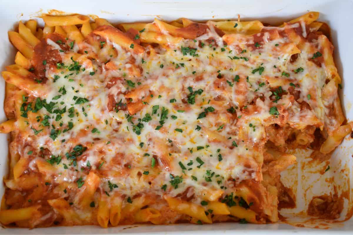 Baked Penne with Ricotta in a white baking dish with parsley sprinkled on top. 