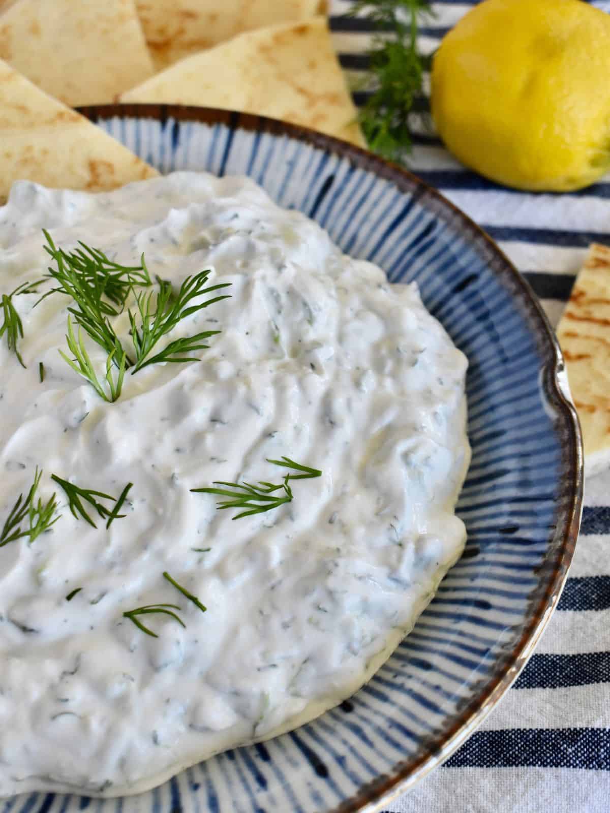 Tzatziki Sauce with sour cream and greek yogurt in a blue bowl. 