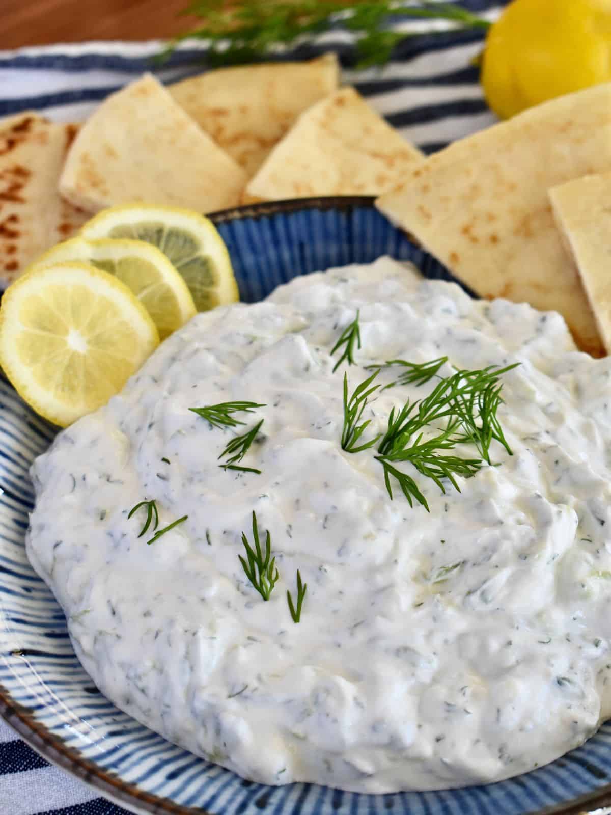 Tzatziki Sauce with sour cream and Greek yogurt is a creamy and delicious dip made with simple ingredients. This creamy tzatziki sauce is extra smooth and is perfect for dipping pita chips or fresh veggies. 