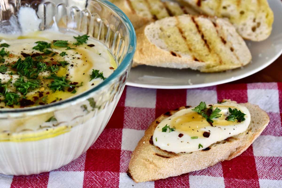 Whipped ricotta dip on a grilled baguette with honey drizzle on top. 
