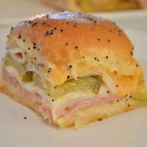 Ham and Cheese Slider on King's Hawaiian Rolls with butter and poppy seeds on top.