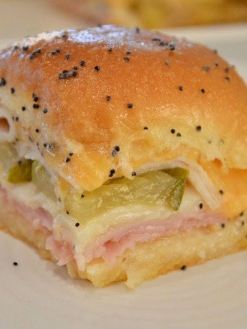 Ham and Cheese Slider on King's Hawaiian Rolls with butter and poppy seeds on top.