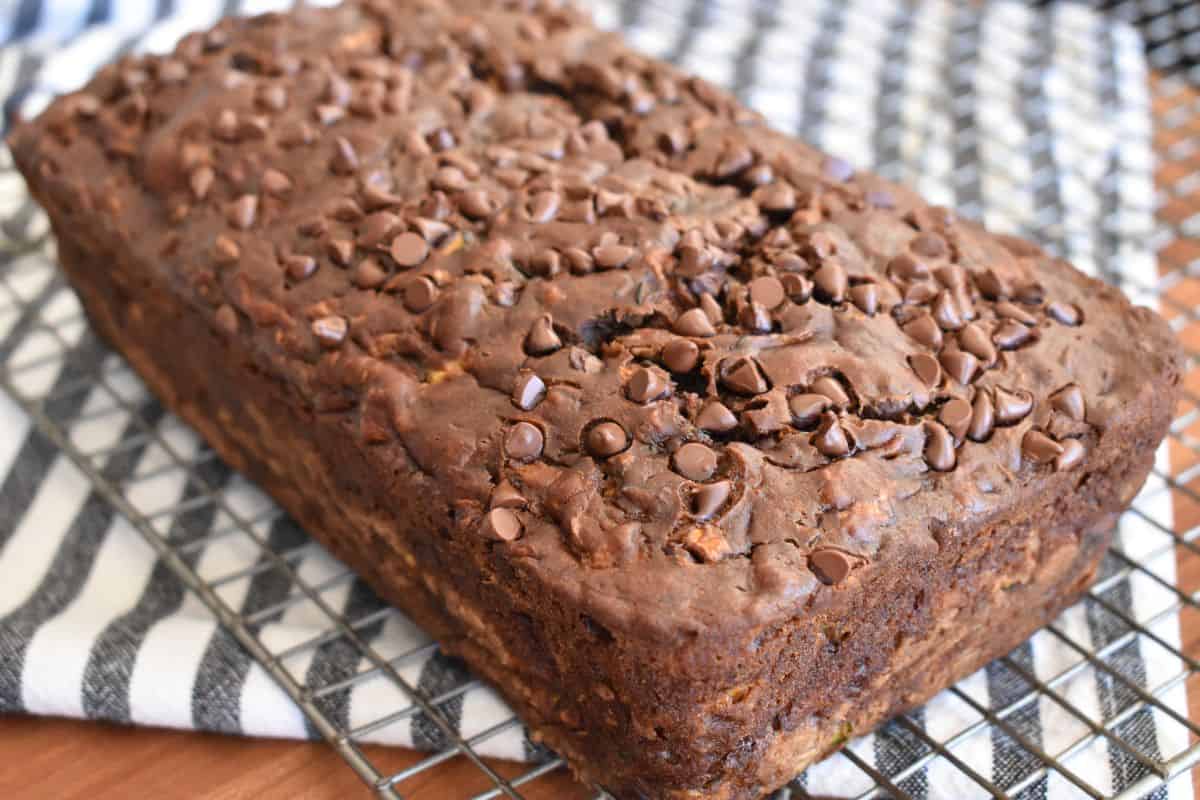 Chocolate Zucchini Banana Bread on a cooling rack with mini chocolate chips baked on top. 