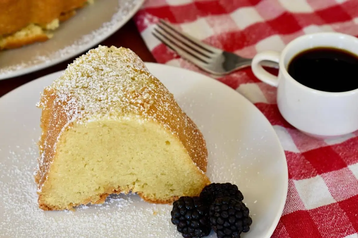 Mascarpone Pound Cake on a white plate with a checkered napkin in the background. 