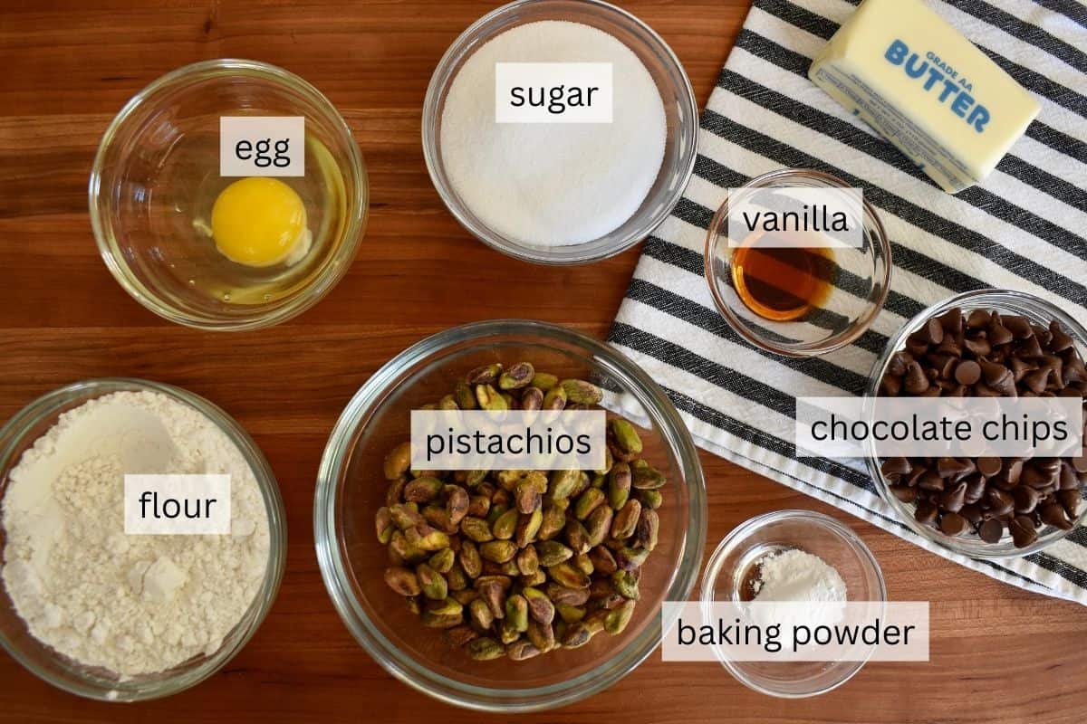 Ingredients for recipe on a wood cutting board including egg, flour, sugar, vanilla, and baking powder. 