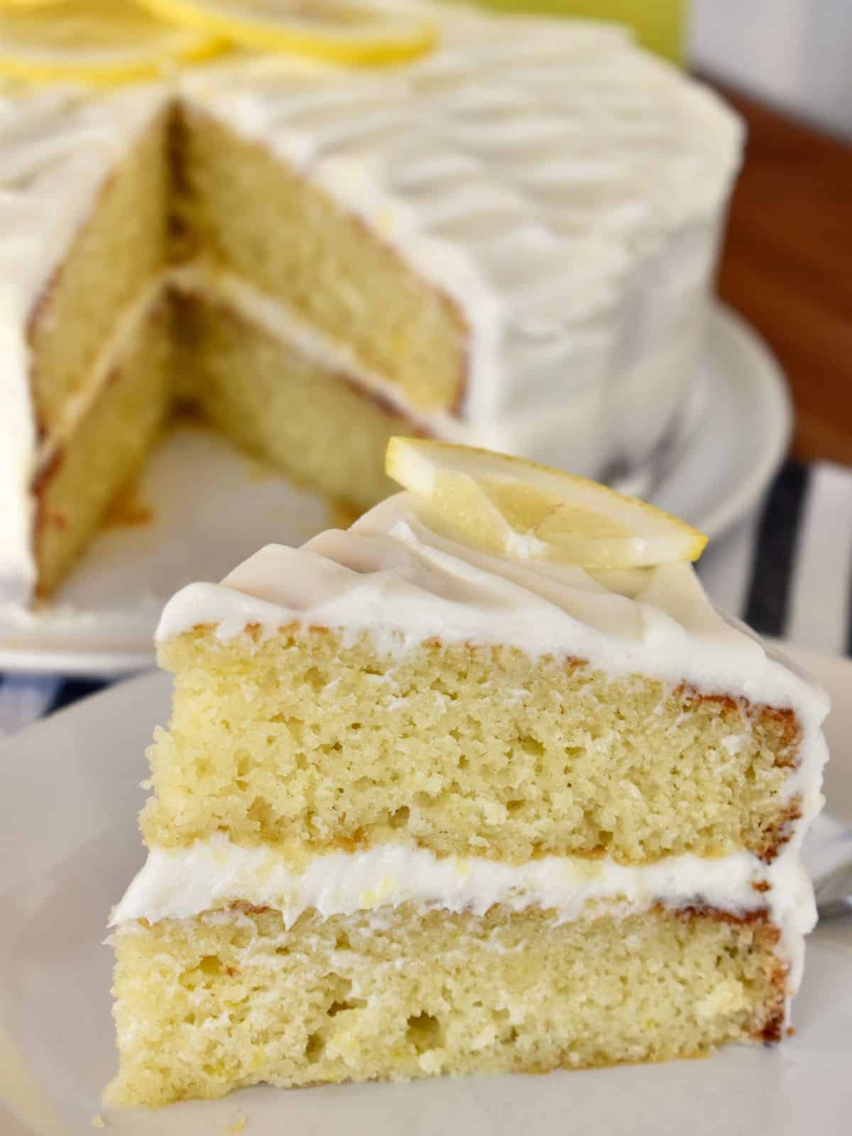 Limoncello Ricotta Cake slice with cream cheese frosting on a white plate. 