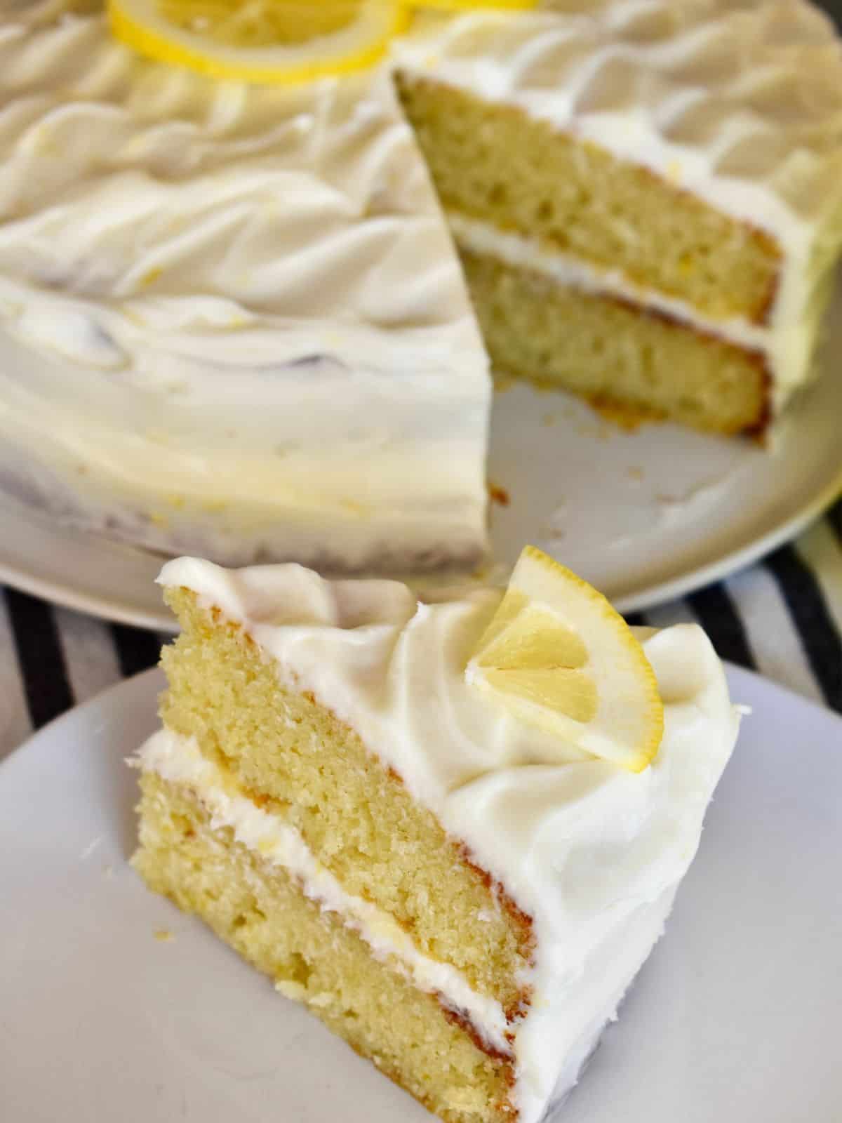 Limoncello Ricotta Cake on a white plate with a lemon slice on top. 