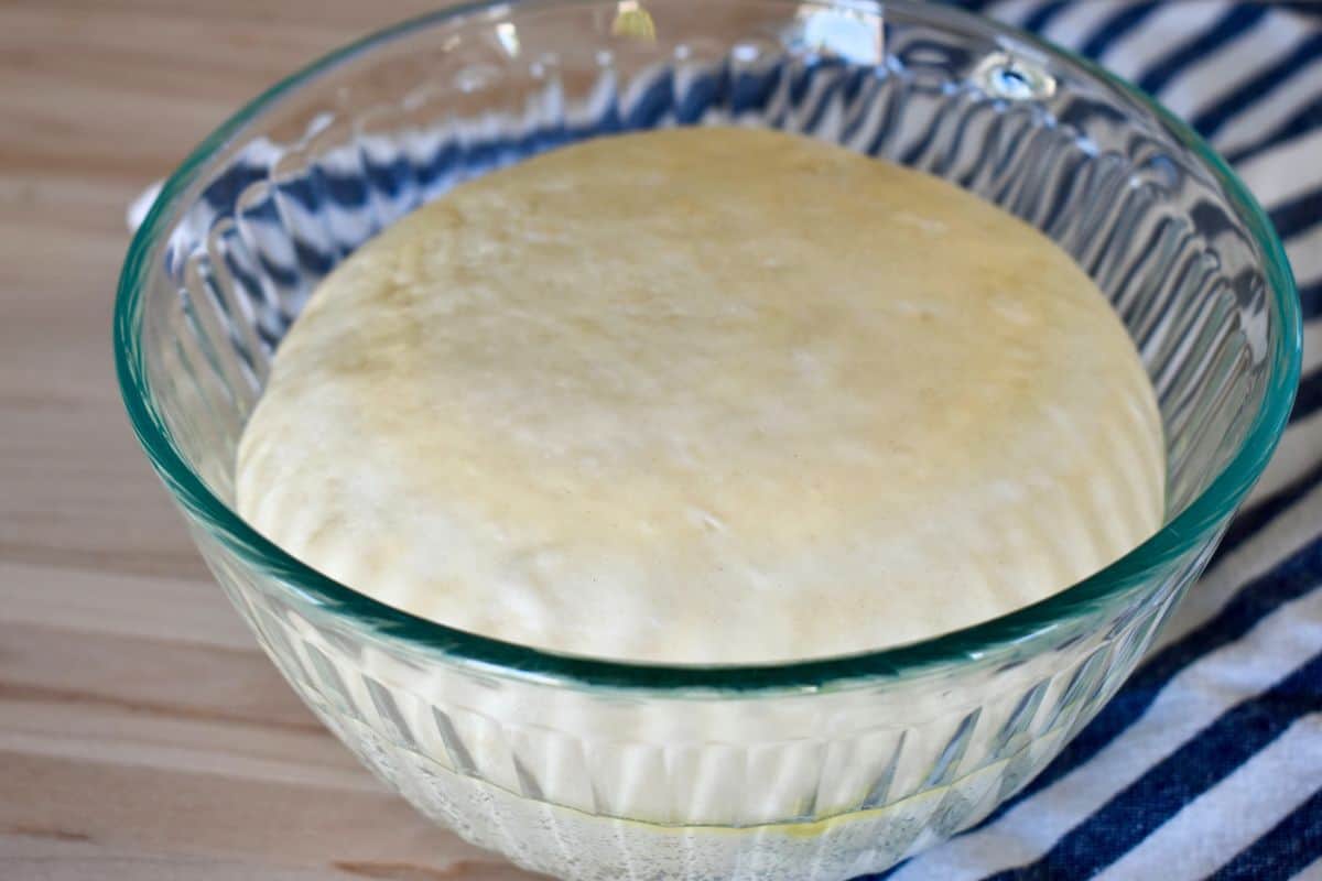 Small batch pizza dough for one pizza in a glass bowl after the dough has risen. 