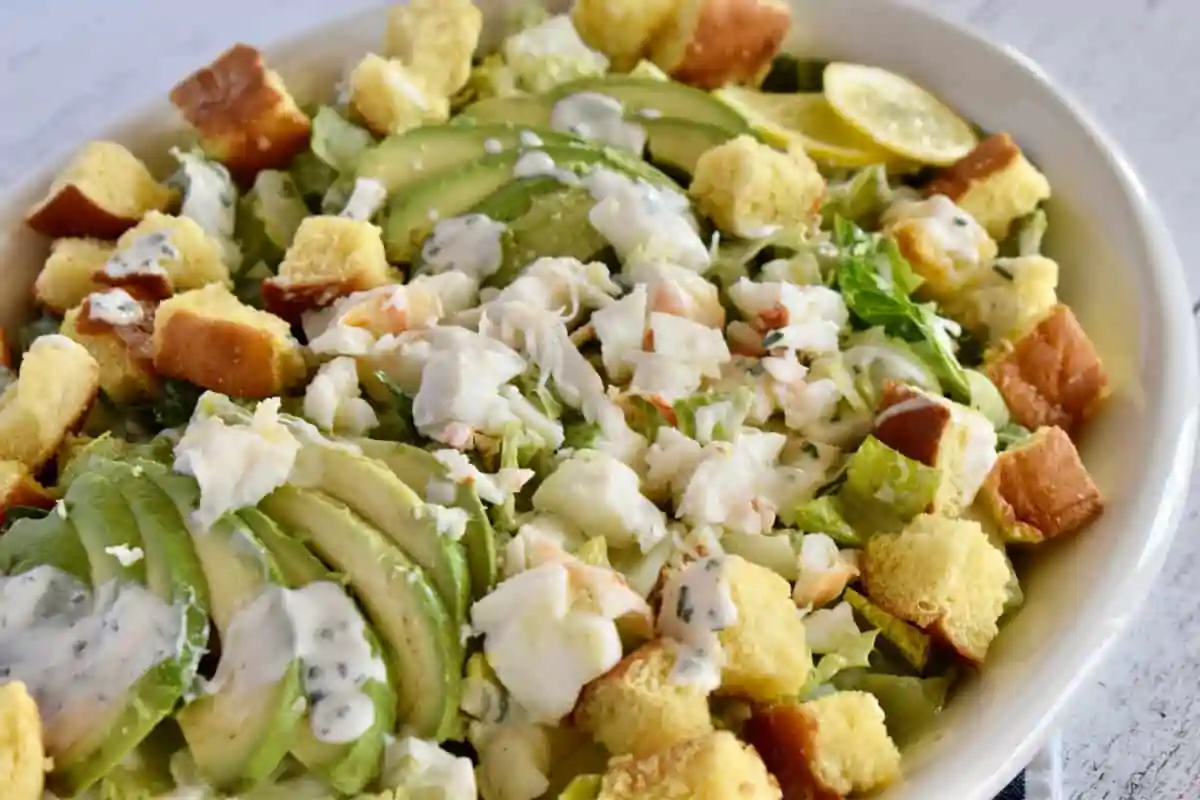 Lobster Roll Salad with brioche croutons in a large white serving dish.