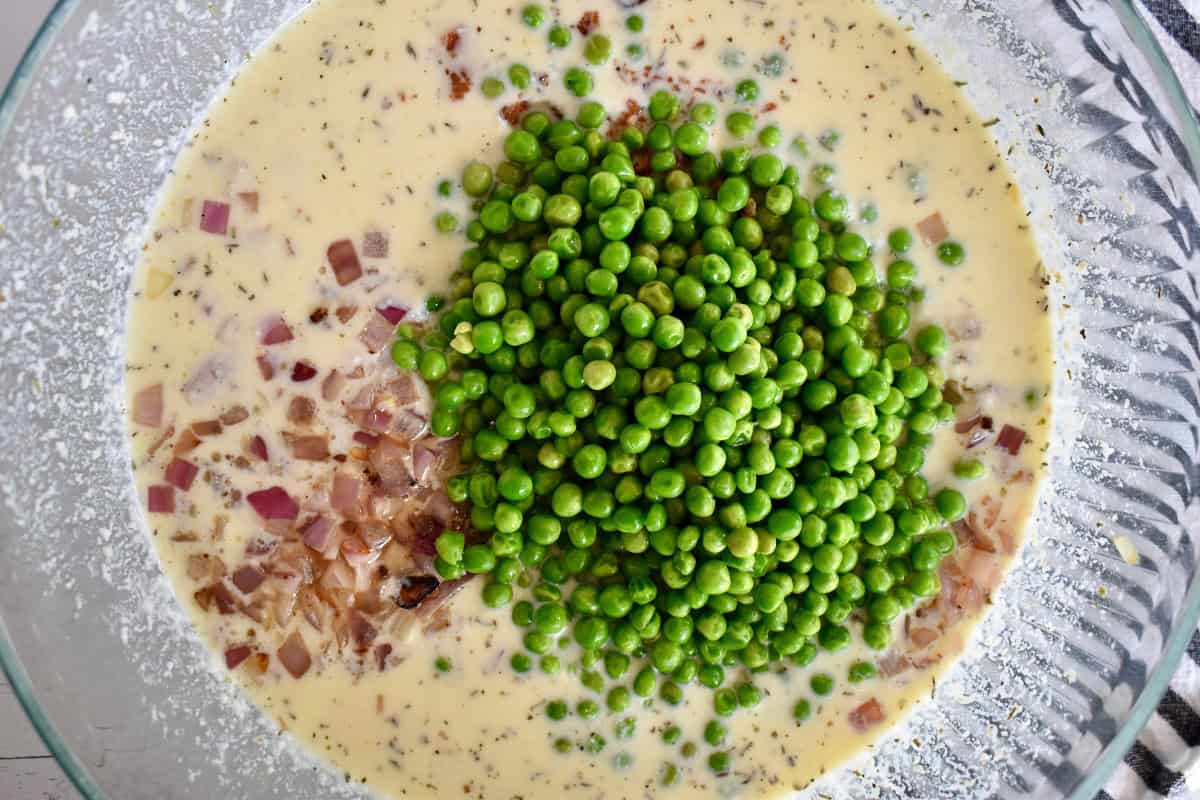 Bowl with the sauce, pasta, bacon, peas and onions.
