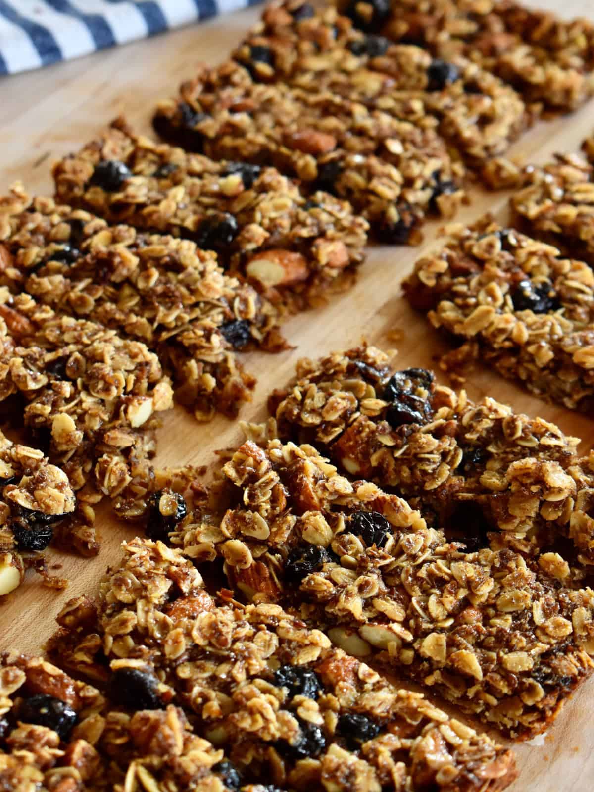 Cranberry Granola Bars with Almonds on a cutting board cut into individual bars.