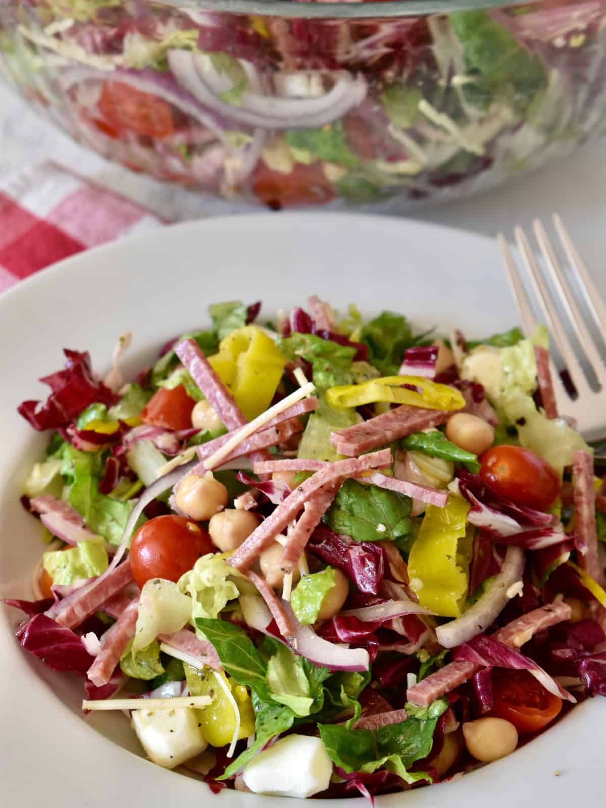 Italian Chopped Salad in a white bowl with a fork.